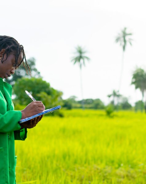 An African female farmer taking notes on a farm